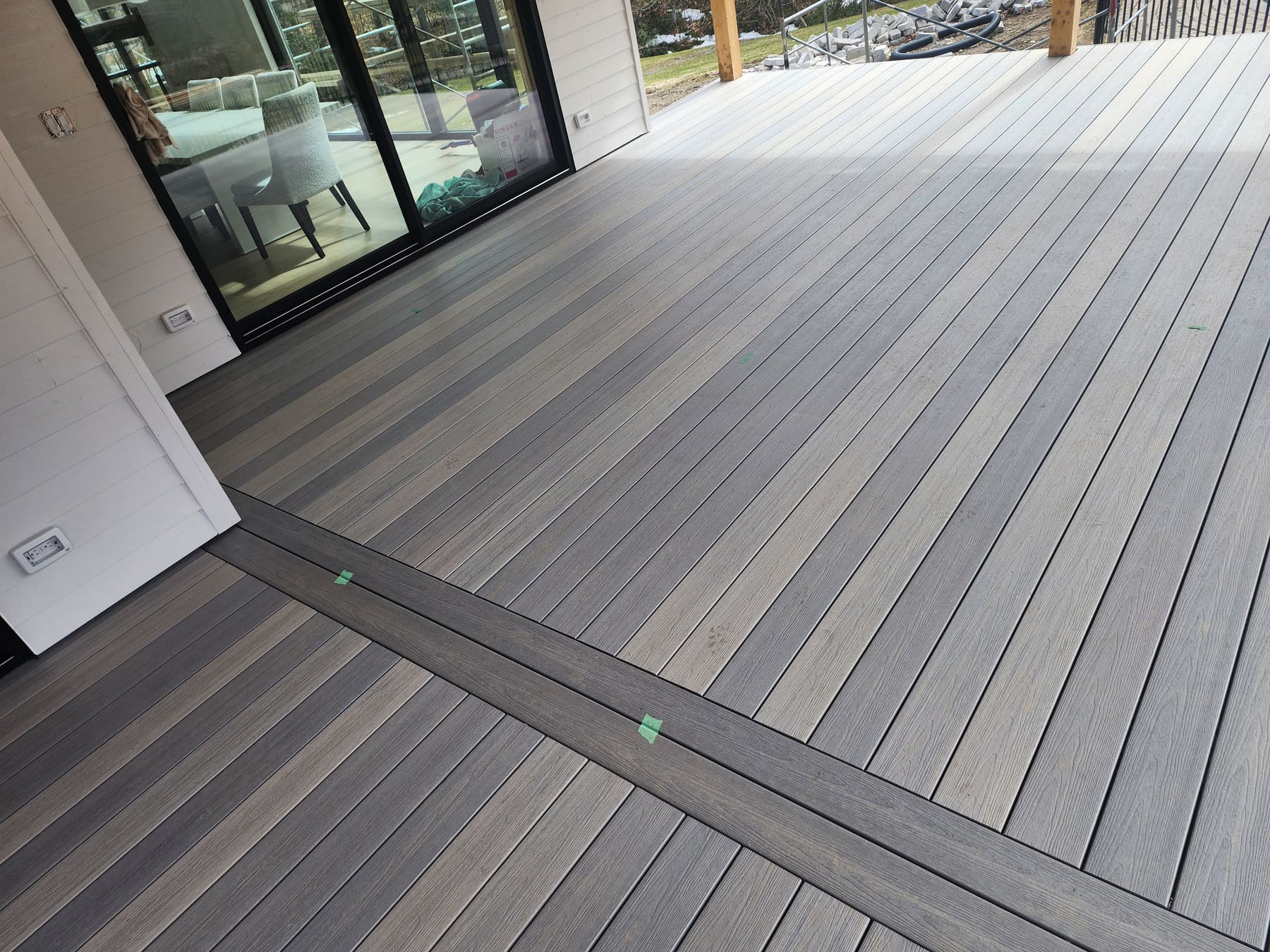 Composite deck flooring installed by ZioConstruction, with a decorative inlay and aligned seams